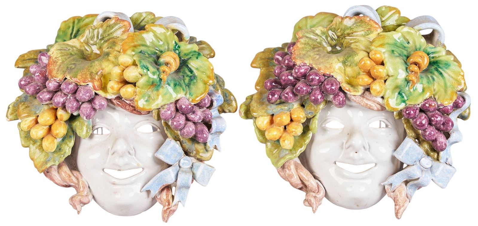 Red McCombs | Pair of Italian Majolica Masks: Pair of Italian glazed majolica wall masks with Bacchanalian design, marked "Made in Italy" height 9 in. x depth 10 in. x depth 4.5 in. / each Provenance: Property from the