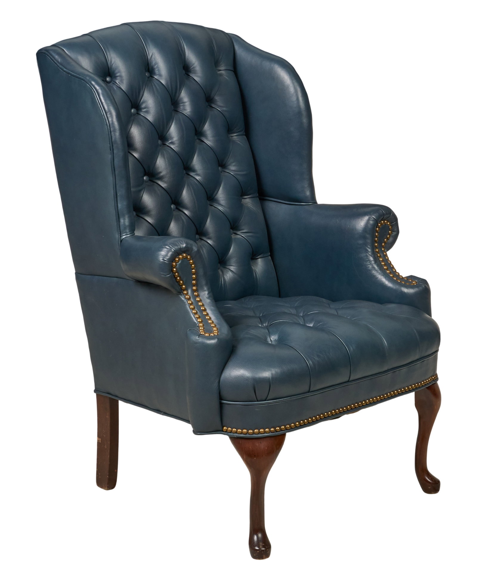 Red McCombs | Leather Wingback Armchair: Tufted blue leather wingback armchair with metal nail trip, supported on cabriole front legs height 42 in. x width 29 in. x depth 24 in. Provenance: Property from the personal estate collec