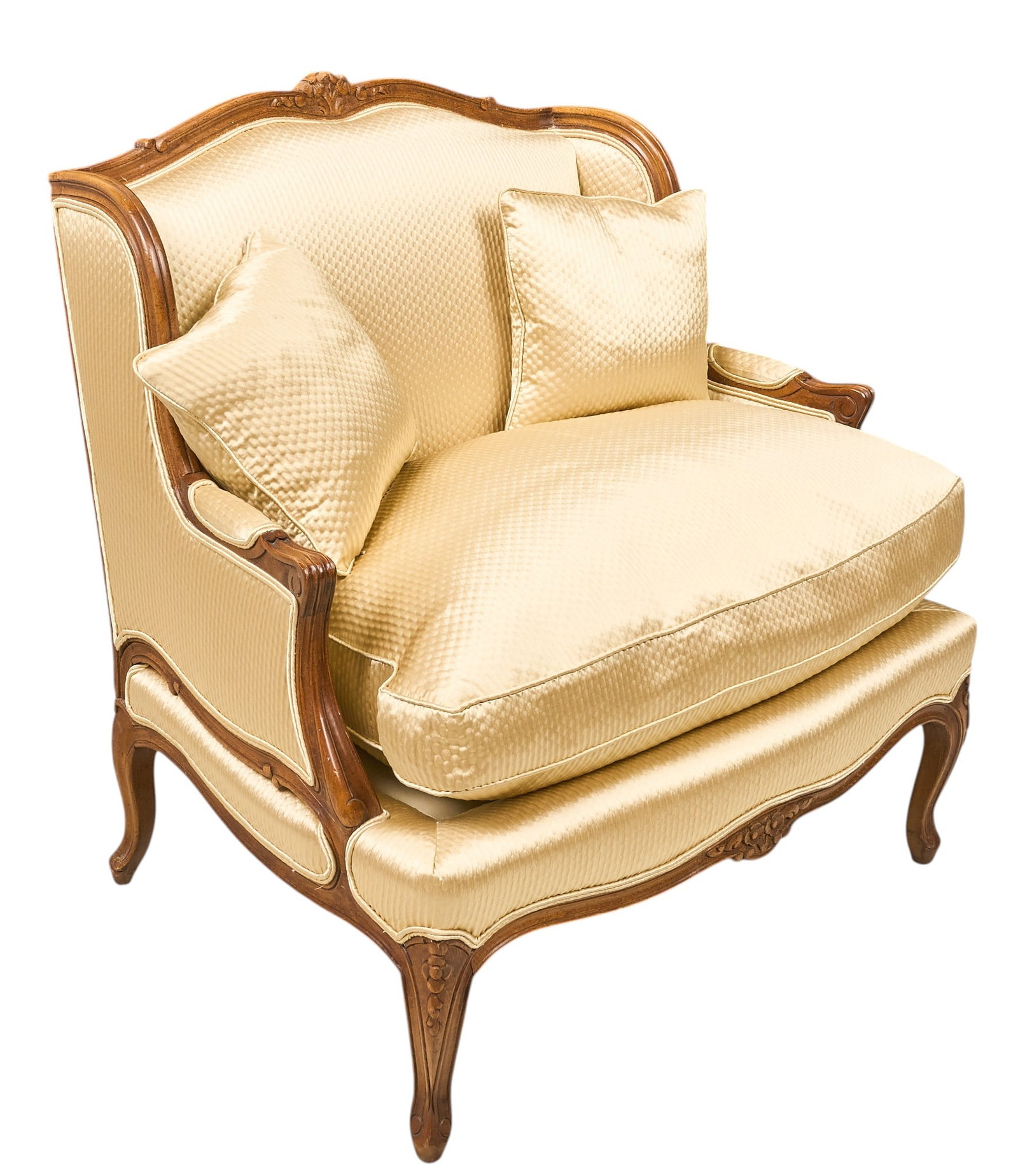 Red McCombs | Louis XV Bergere: French Louis XV style carved walnut bergère, with shaped upholstered back and enclosed sides, scrolling open arm terminals and floral-carved apron, raised on cabriole legs, upholstered in cream