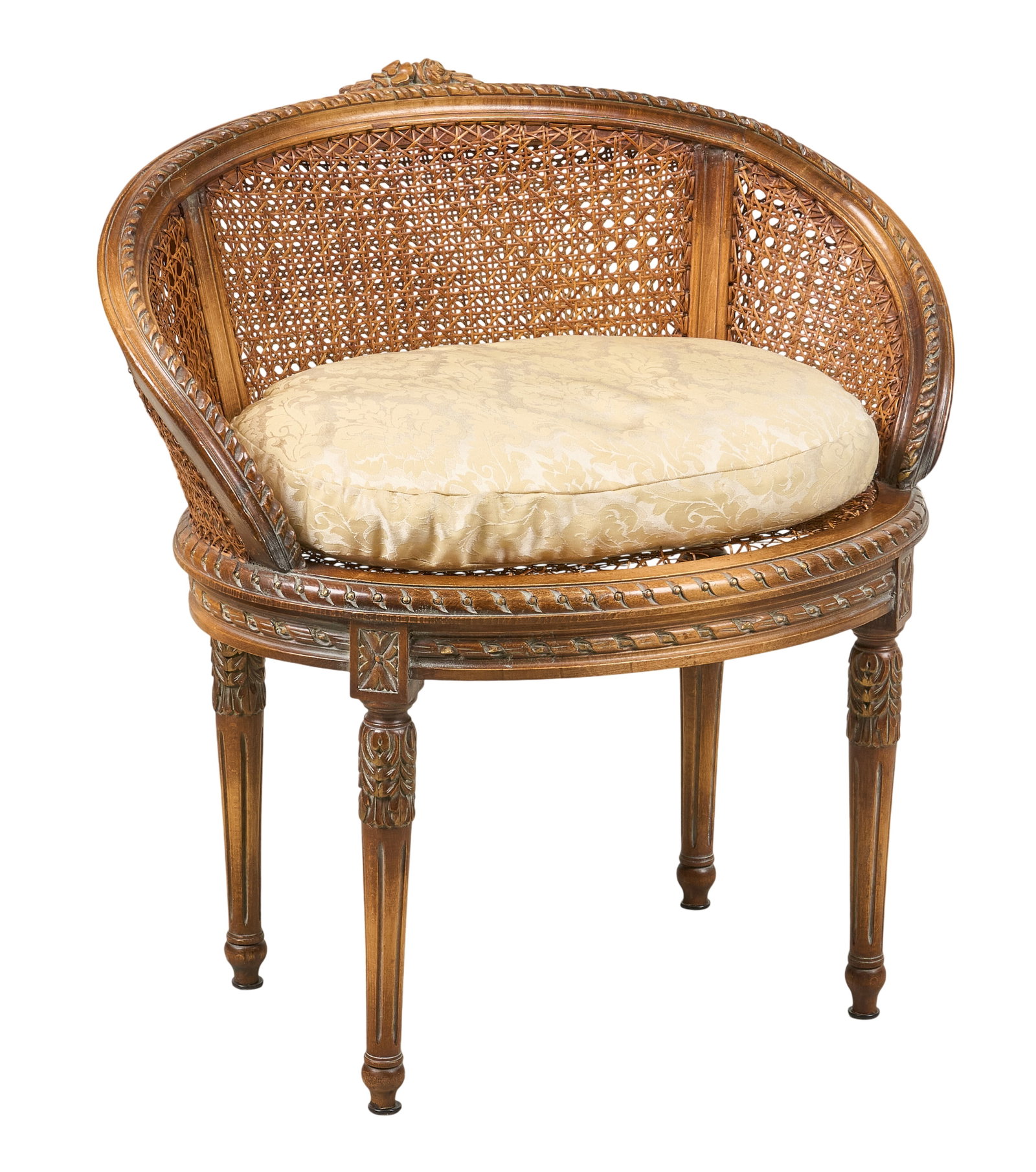 Red McCombs | Louis XVI Style Cane Chair: Louis XVI style round caned tub chair featuring layered open-weave curve backrest, cream-colored upholstered seat cushion, and fluted legs height 20 in. x width 29 in. x depth 21 in. Provenance: