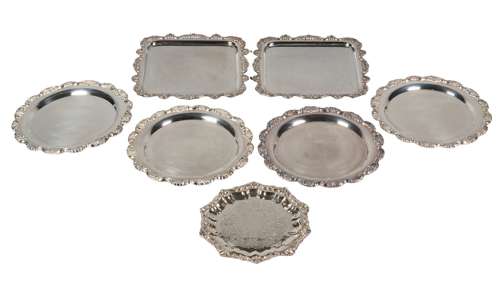 Red McCombs | (7) Vintage Silverplate Service Trays: Seven vintage silverplate service trays, each featuring scalloped edges and repousse design height 1 in. x diameter 14 in. / largest Provenance: Property from the personal estate c
