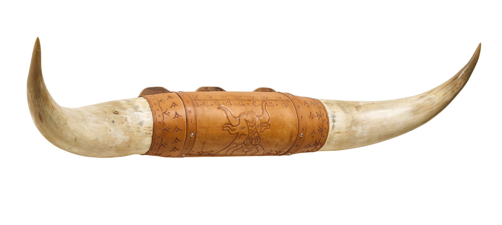 Bull Horn Mount: Monumental set of bull horns mounted to wooden board, decorated with leather band with tooled bull motif height 17 in x width 57 in. x depth 12 in. Provenance: Property from a San Antonio, Texas