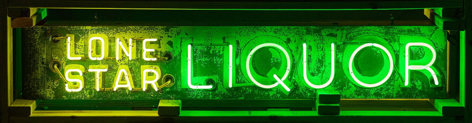 Lone Star Liquor Neon Sign: Lone Star Liquor neon sign, double-sided, made from vintage painted metal sign with newer neon tubing, housed in custom shipping crate height 12 in. x width 70 in. x depth 10.5 in. Provenance: