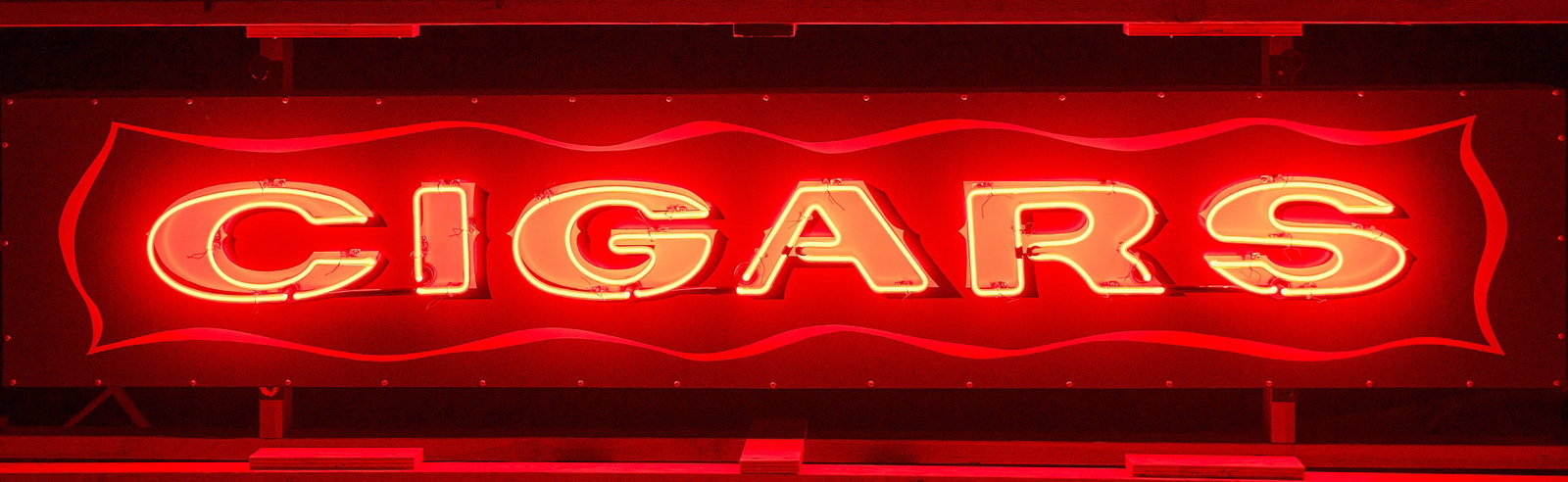 Cigars Neon Sign: Single-sided Cigars neon sign, with hanging hooks, housed in custom shipping frame height 22 in. x width 96 in. x depth 8.5 in. Provenance: Property from a home in San Antonio, Texas 