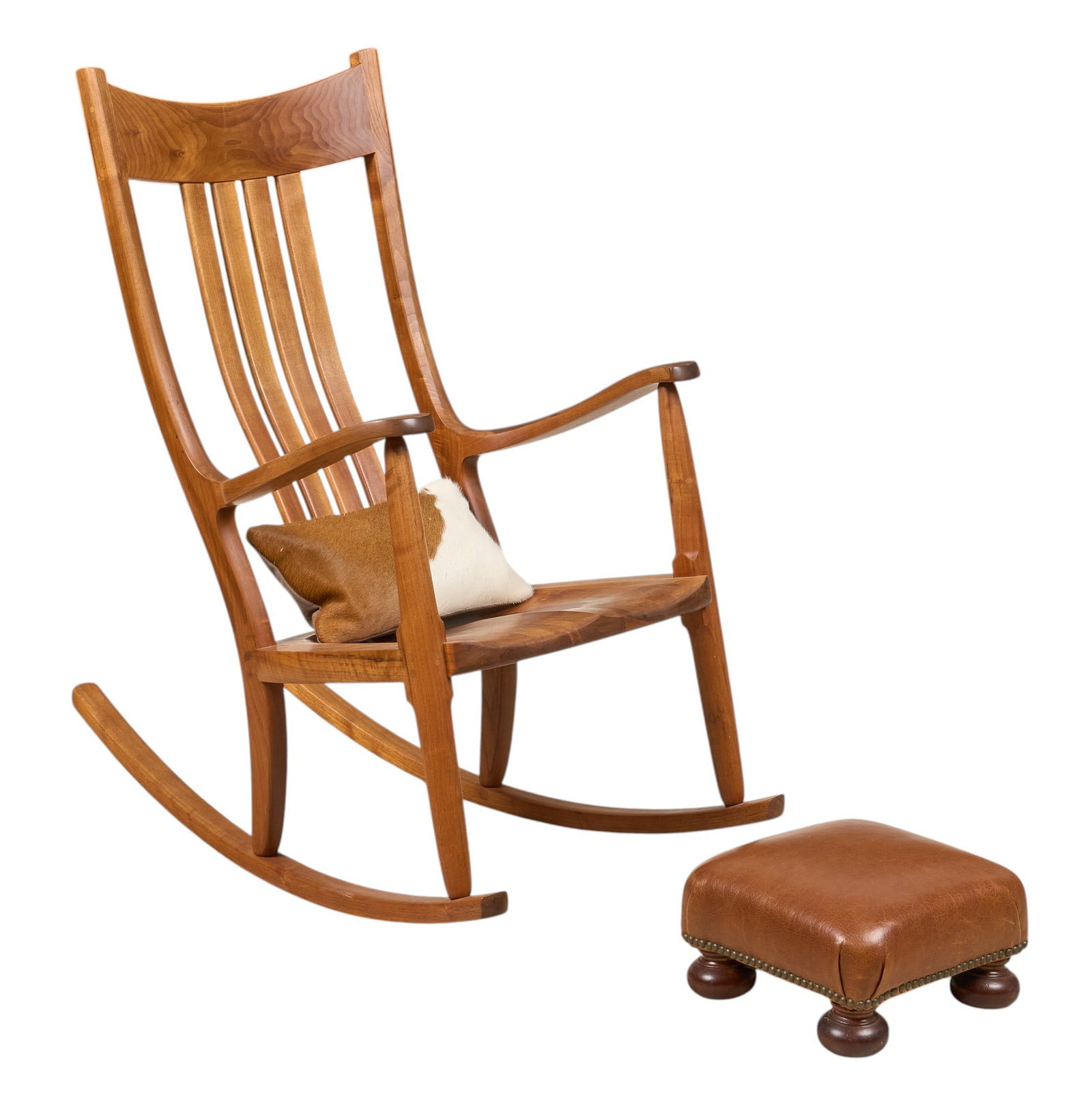 Gary Weeks Walnut Rocker: Gary Weeks walnut rocking chair, with longhorn hide cushion, and leather ottoman supported on bun feet height 45 in. x width 26.5 in. x depth 40 in. / rocker Provenance: Property from the personal