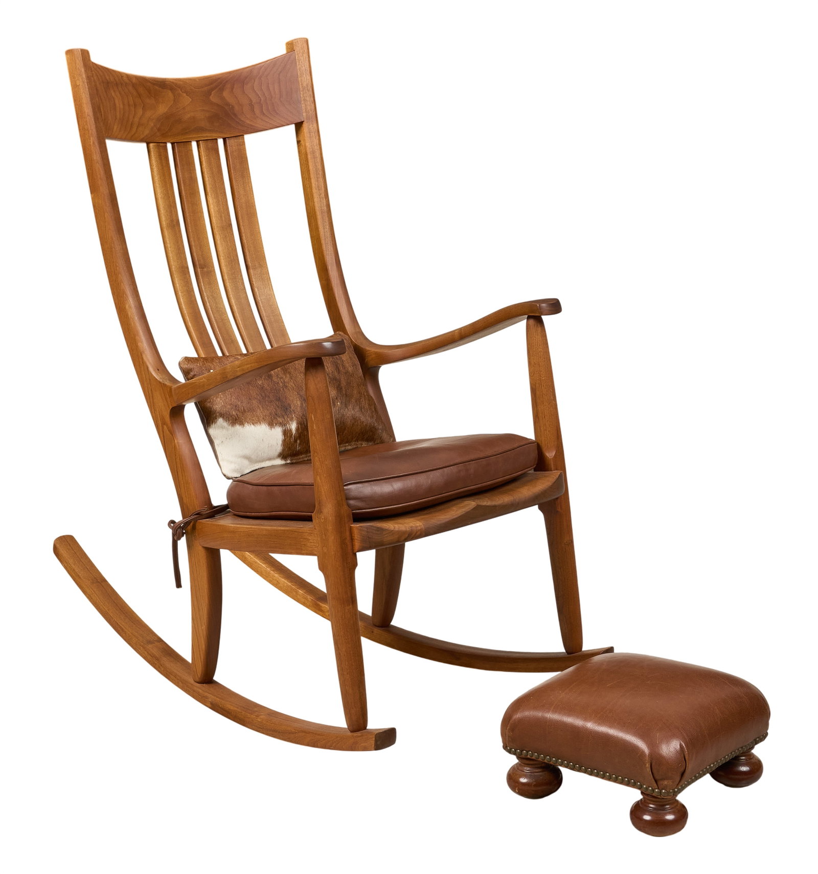 Gary Weeks Walnut Rocker: Gary Weeks walnut rocking chair, with longhorn hide cushion, and leather ottoman supported on bun feet height 45 in. x width 26.5 in. x depth 40 in. / rocker Provenance: Property from the personal