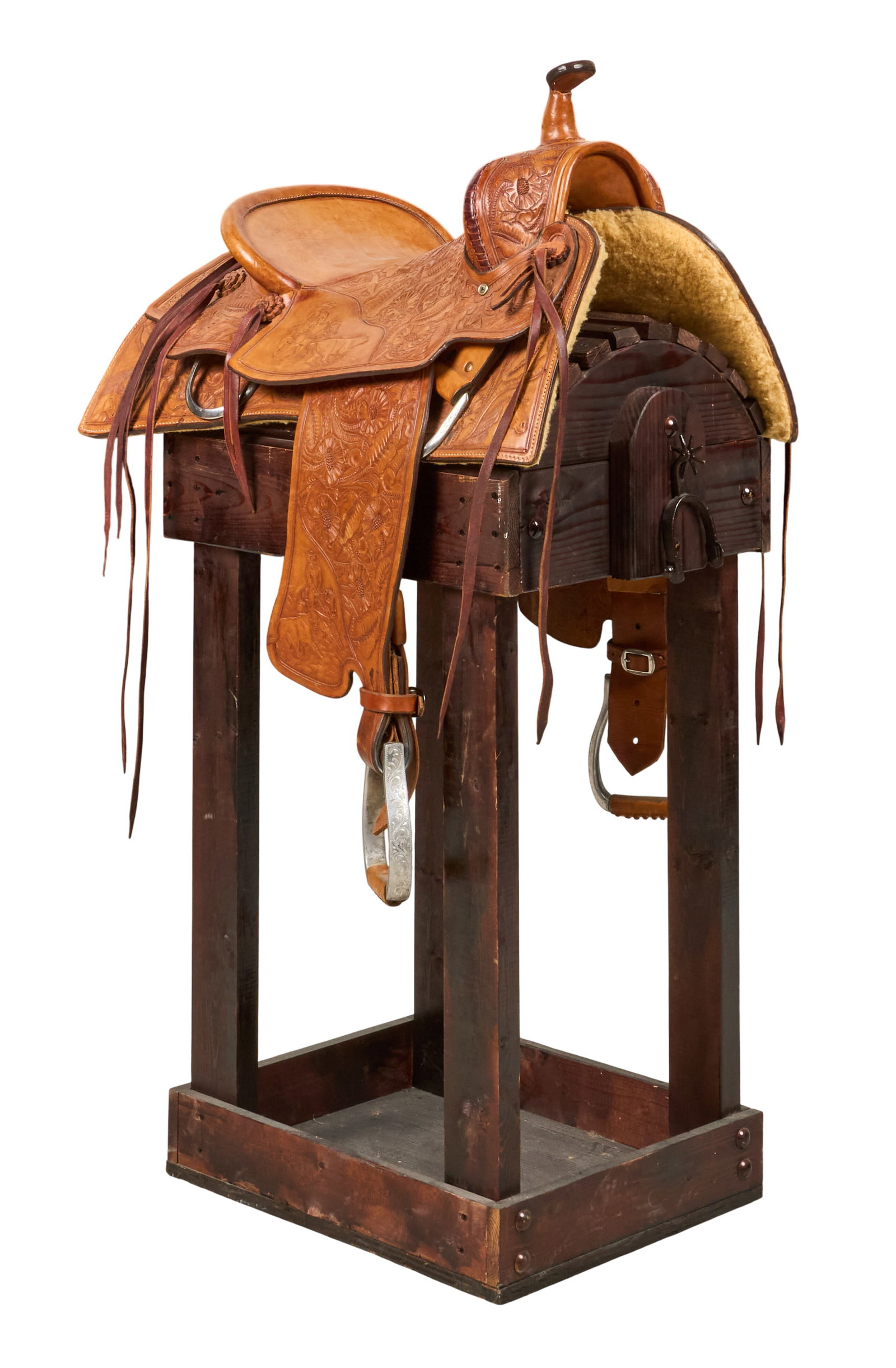 Fully Tooled Western Saddle: Fully tooled riding saddle featuring Western motifs depicting steers, cowboys roping steers, and cattle brand height 38 in. x width 31 in. x depth 21 in. length: 16.5 in. / seat 