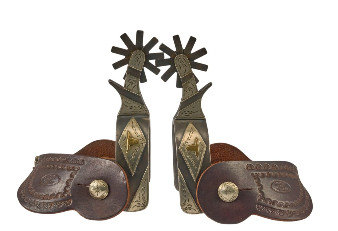 Pair of Jim Bergby Texas Longhorn Spurs: Pair of Jim Bergby Texas longhorn pattern spurs, marked "T-T" on interior heel band, with silver overlay featuring longhorn motif, and tooled leather heel strap overall length: