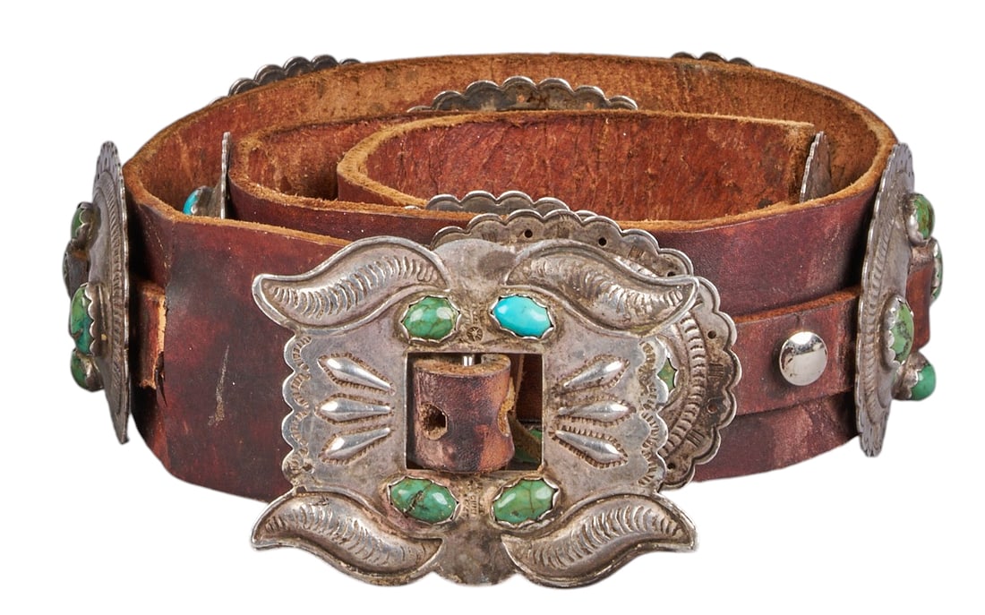 Vintage Navajo Silver and Turquoise Concho Belt: Vintage Navajo sterling silver concho belt featuring nine conchos and buckle on brown leather belt, conchos set with turquoise cabochons and stamped details Length: 44 in. Provenance: Property