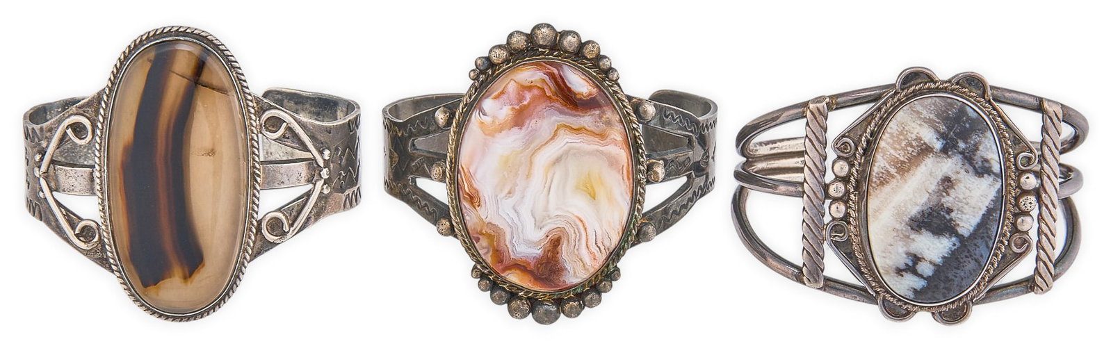 (3) Sterling & Agate Cuffs: Three sterling silver cuff bracelets, each set with large agate cabochon, twisted wire motifs, and stamped details, marked Circumference: 6.5 in. / largest Total weight: 145.1 g Provenance: Property f
