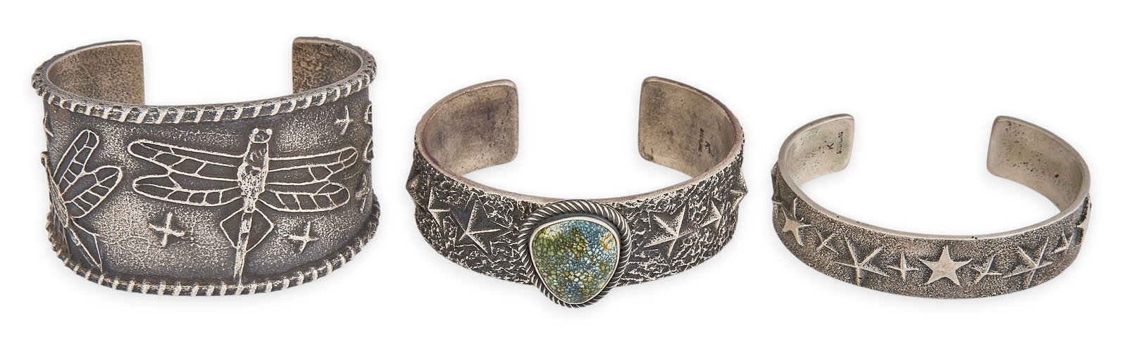 (3) Tufa Cast Sterling Cuffs: Three tufa cast sterling silver cuff bracelets, to include one example by Monty Claw, featuring various motifs, one cuff set with turquoise cabochon, marked Circumference: 7 in. / largest Total w
