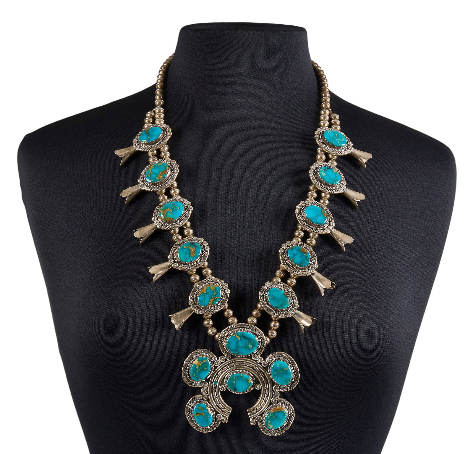 Sterling & Turquoise Squash Blossom: Sterling silver squash blossom necklace set with oval turquoise cabochons in twisted wire style settings, featuring hand-stamped details throughout, with hook and eye closure, marked "NE Sterling