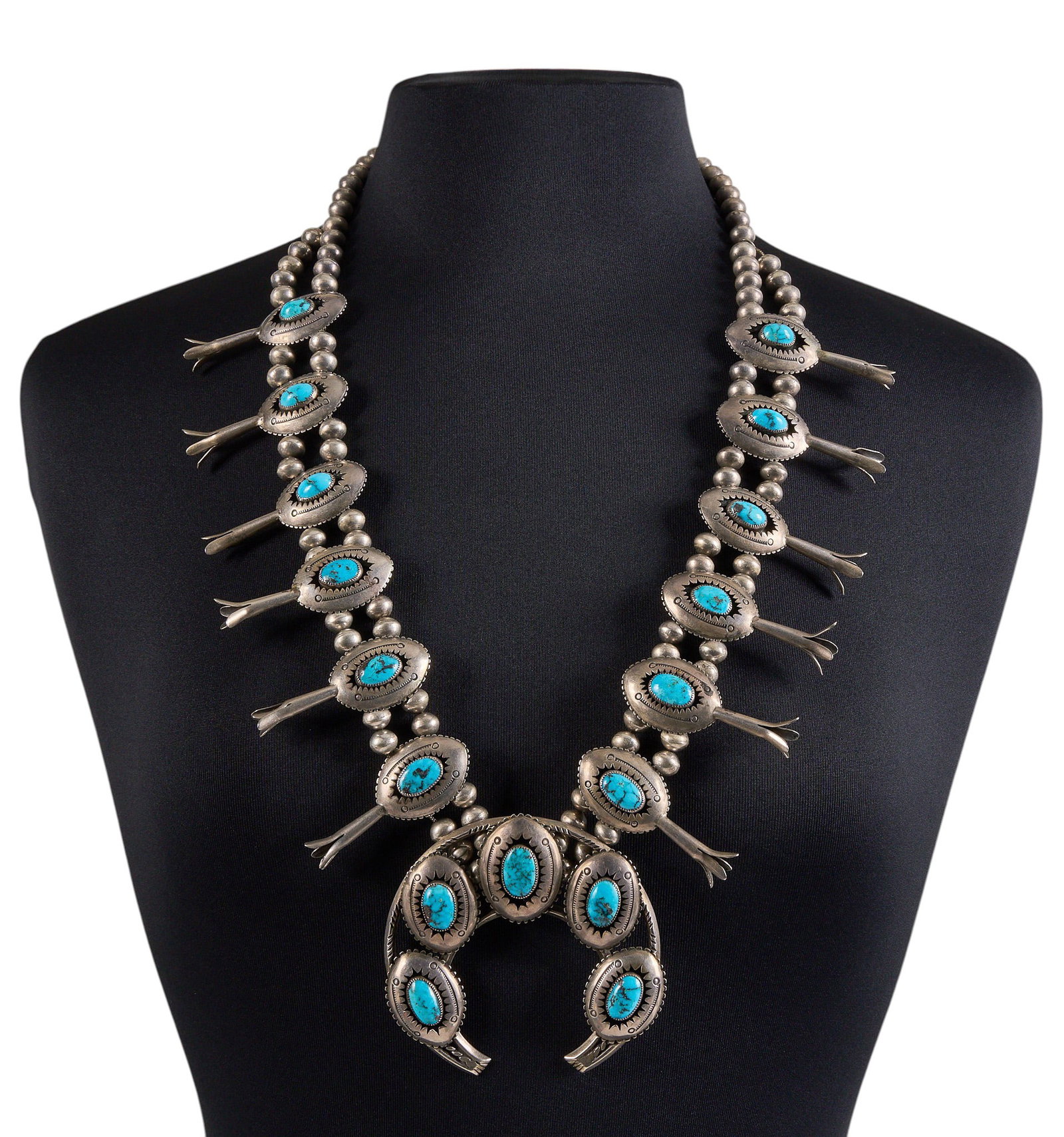 Vintage Navajo Sterling & Turquoise Squash Blossom: Vintage Navajo sterling silver squash blossom necklace set with oval turquoise cabochons in shadowbox style settings, featuring hand-stamped details, and hook and eye closure Length: 31 in. Total