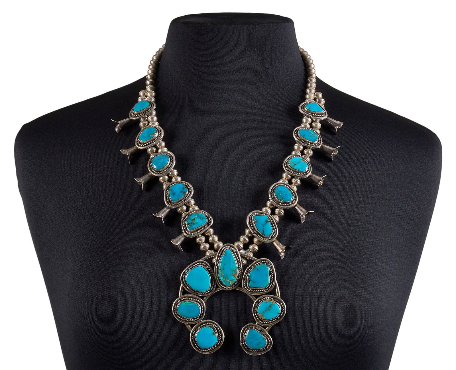 Vintage Southwestern Sterling & Turquoise Squash Blossom: Vintage Southwestern sterling silver squash blossom necklace, set with large turquoise cabochons in twisted wire bezel settings, with large naja and hook and eye closure Length: 24.5 in. Tot