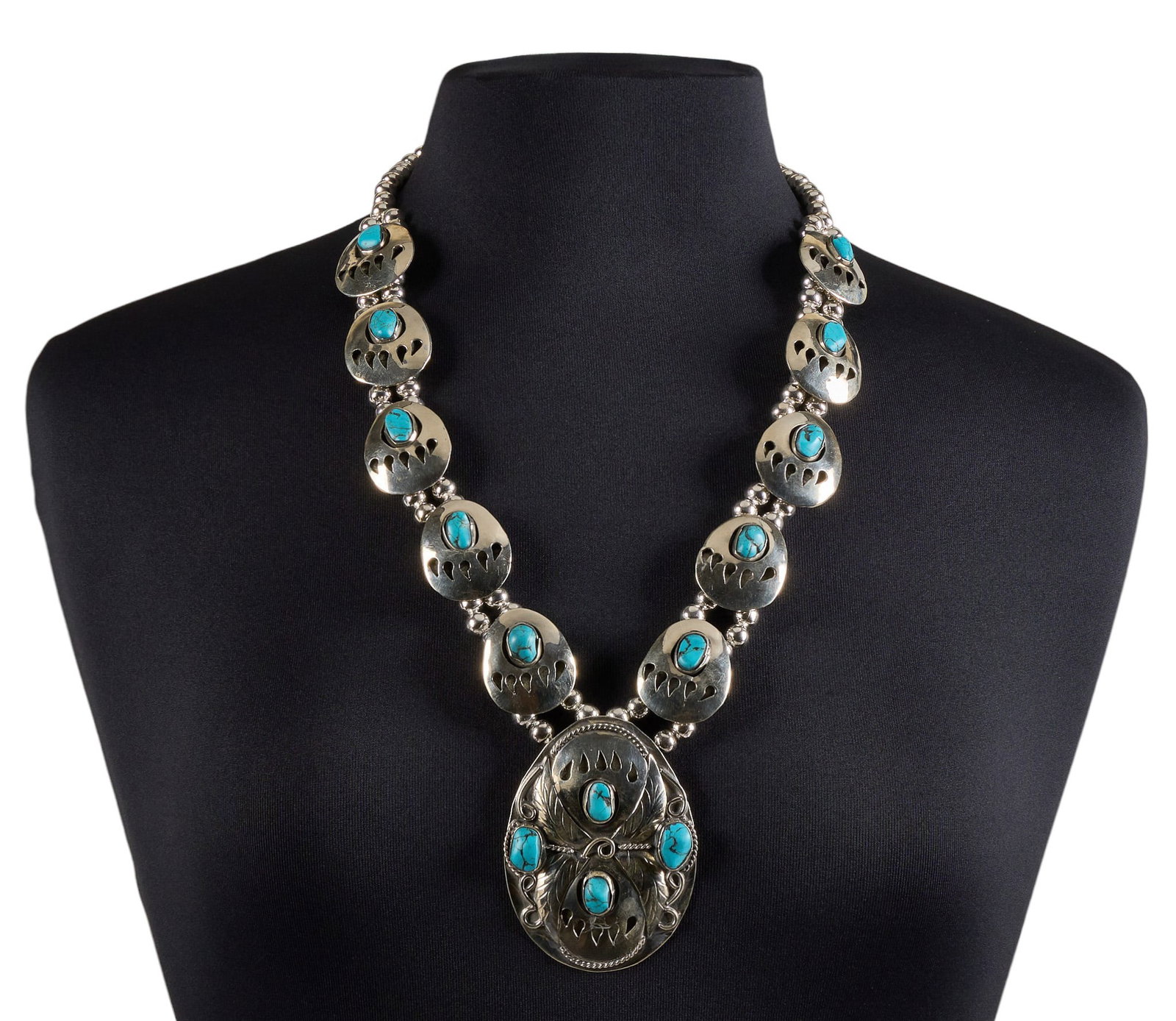 Vintage Native American Turquoise Bear Paw Necklace: Vintage Native American necklace featuring handcrafted coin silver bear paw motif side settings and a matching bear paw naja pendant, accented by Stormy Mountain turquoise cabochons, on graduated