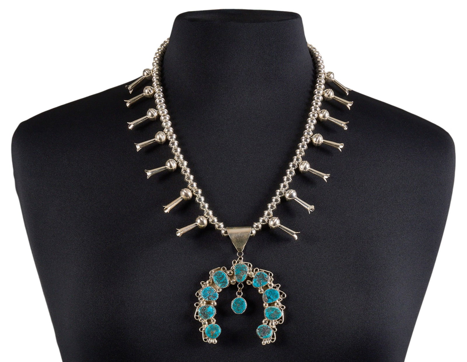 Derrick Nez, Navajo Sterling & Turquoise Squash Blossom: Derrick Nez, Navajo sterling silver squash blossom necklace, set with turquoise cabochons to naja, with hook and eye closure Length: 22 in. Total weight: 75.0 g Provenance: Property from a h