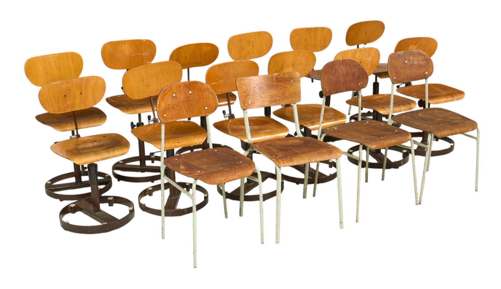 (16) Institutional Chairs: Mixed collection of chairs, includes a set of twelve stools with wooden seats, swivel bases and articulated backrest that flips over, and a set of four wooden schoolhouse desks on metal legs height