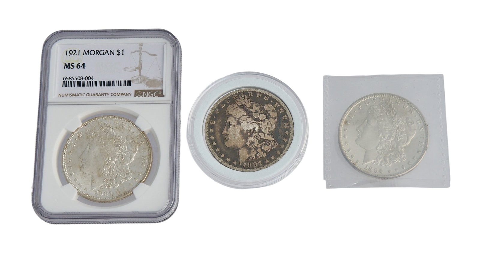 (3) Silver Morgan Dollars: Two silver Morgan Dollars, from 1896, 1897, and 1921, one slabbed and graded MS-64 Provenance: Property from a home in San Antonio, Texas