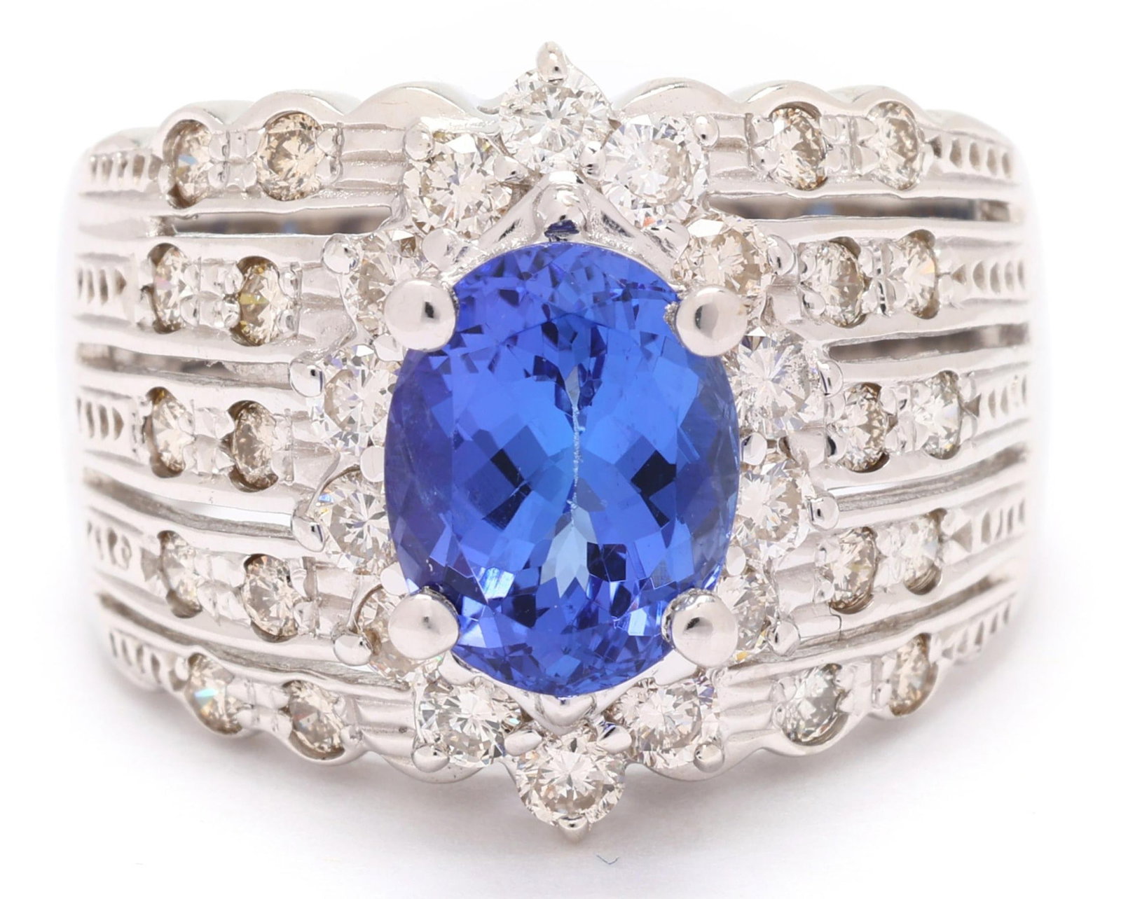 18K Le Vian Diamond Tanzanite Ring: 18K gold ring centering an oval-cut tanzanite measuring 9.0 x 7.0 x 4.90 mm, approximately 2.05 ct, accented by halo of full-cut round diamonds and wide band set with five rows of additional
