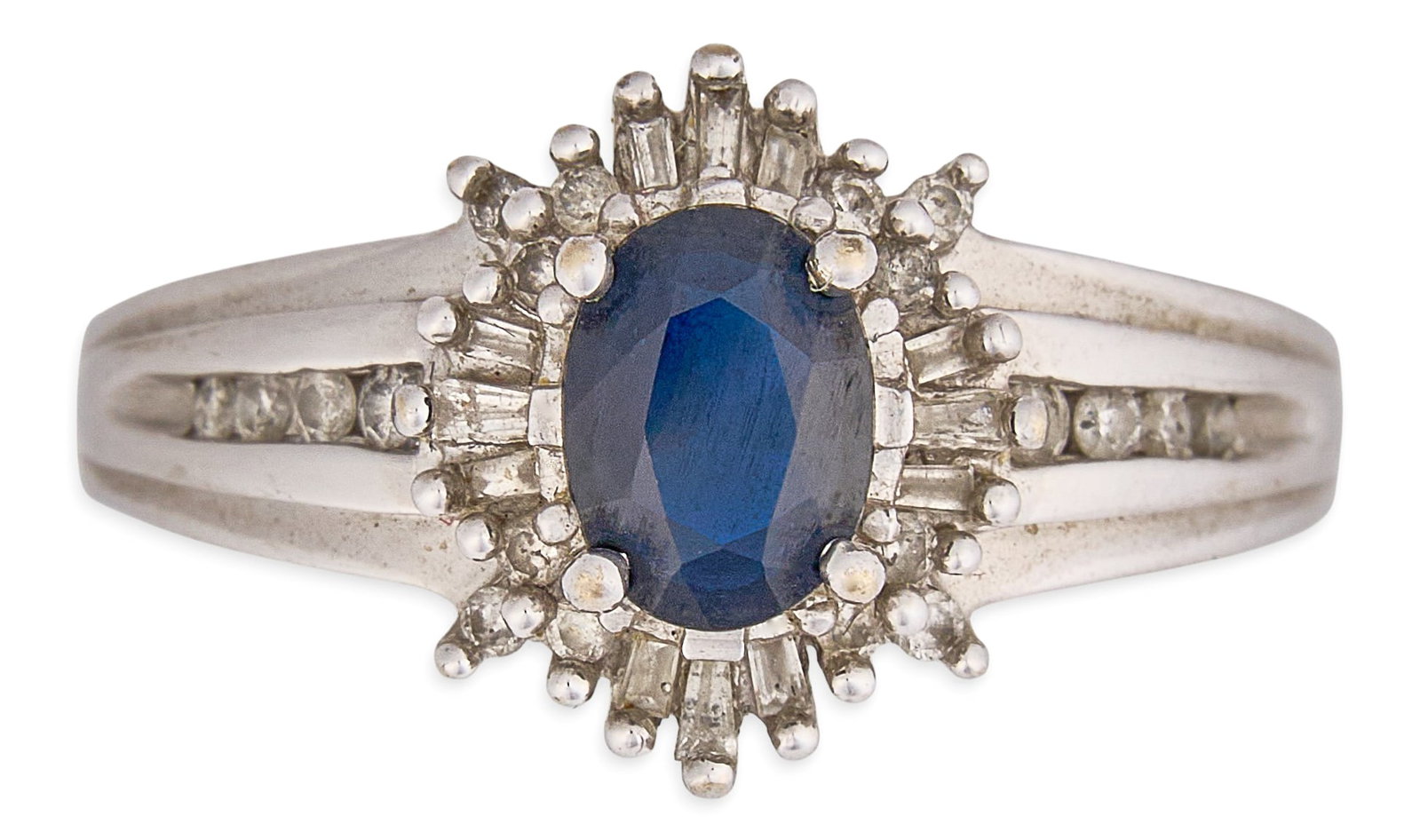 14K Sapphire and Diamond Ring: 14K white gold ring centering an oval-cut sapphire, accented by halo of round and baguette-cut diamonds, with additional round diamonds to shank, marked "14K" Size: 7 Total weight: 4.4 g&nbs