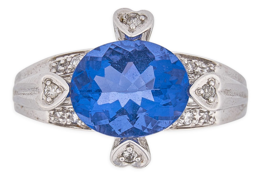 14K Topaz & Diamond Heart Ring: 14K white gold ring centering a faceted oval-cut blue topaz, accented by four round diamonds in heart motif settings, with additional diamond details to band, marked "14K" Size: 8 Total weig