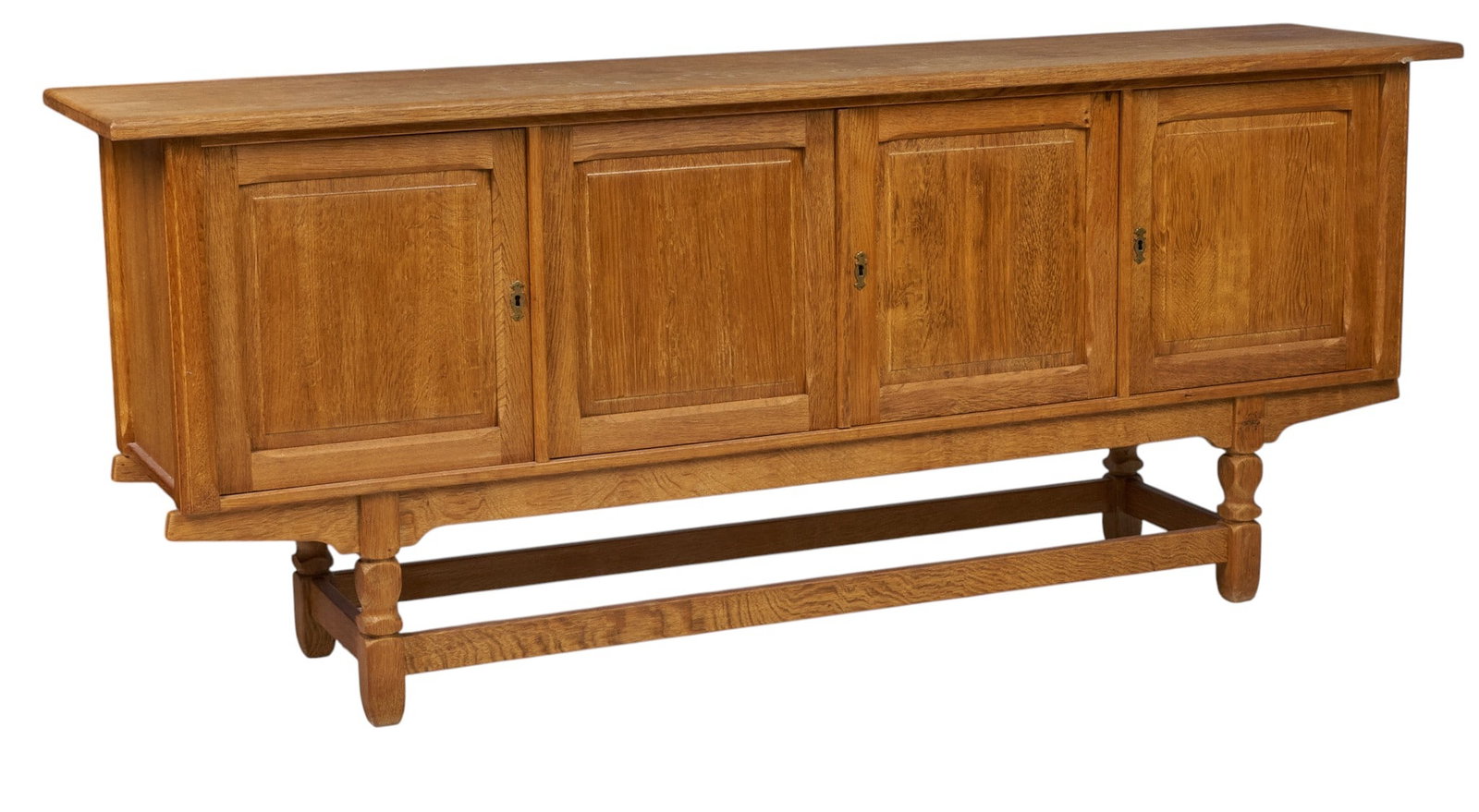 Henning Kjaernulf, Mid-Century Credenza: Henning Kjaernulf (Denmark) oak mid-century credenza with four paneled cabinet doors opening to shelved interior, supported on faceted block legs, includes one key height 35..5 in. x width 85 in. x de
