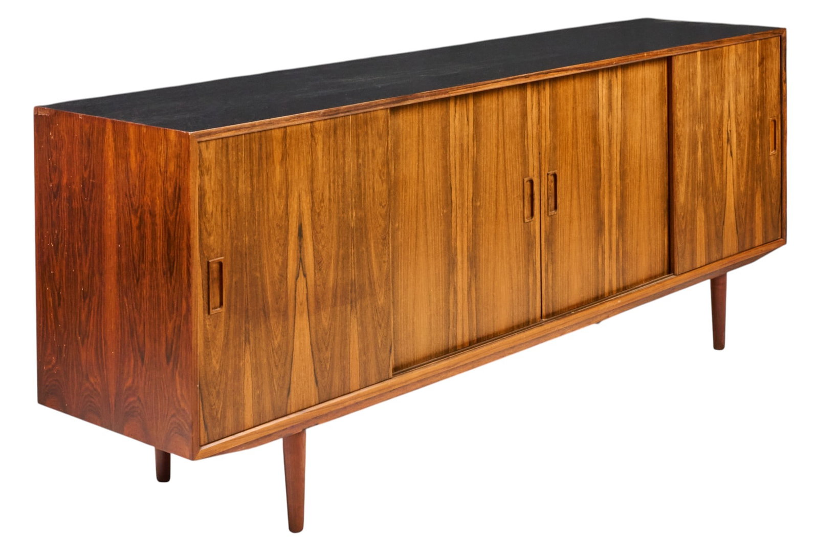 Danish Mid-Century Rosewood Credenza: Danish mid-century rosewood credenza, rectangular case with contrasting black top, four sliding doors with recessed pulls, book-matched figured grain, raised on tapered legs height 31 in. x width