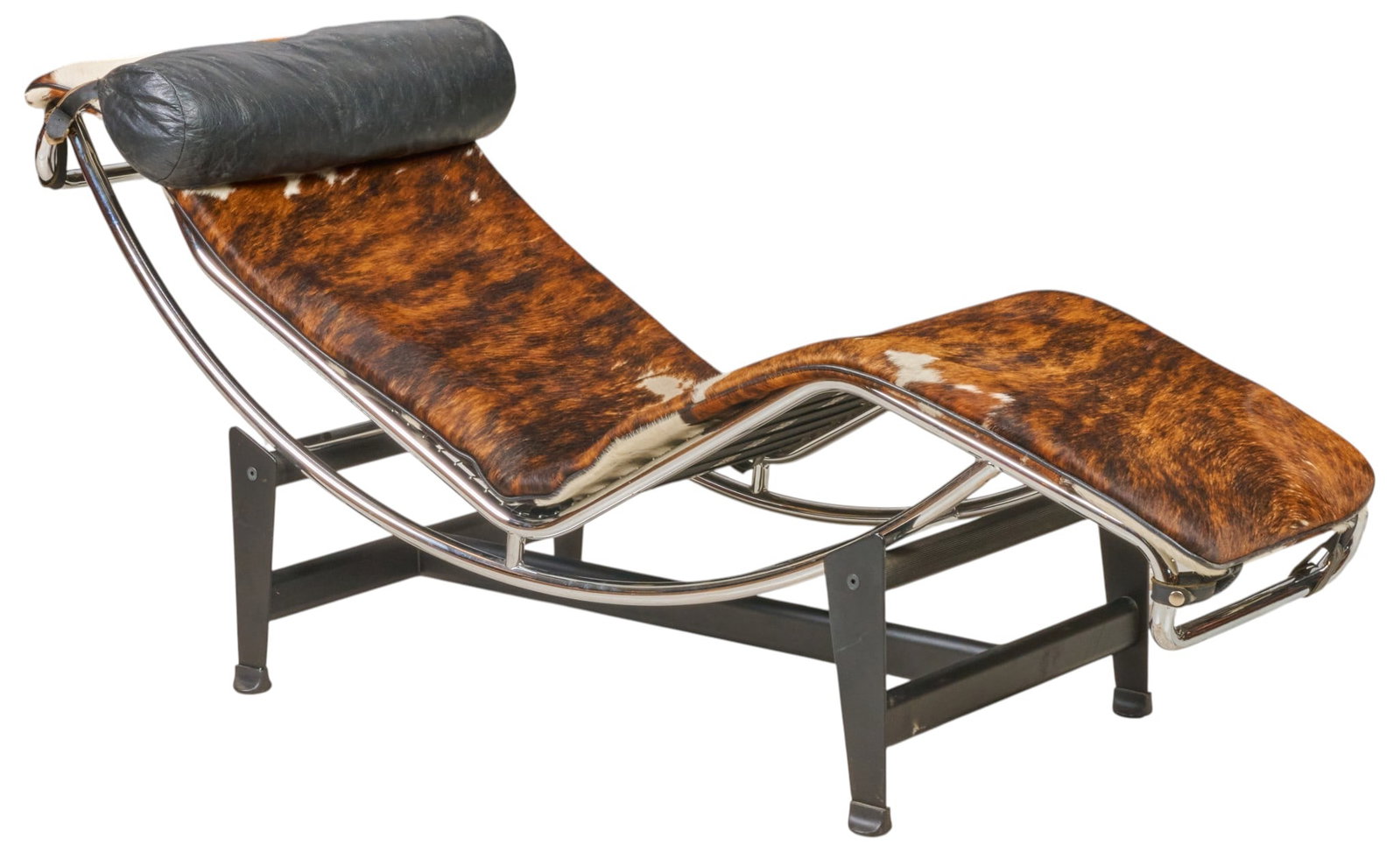 After Le Corbusier, Chaise Lounge Chair: Mid-century lounge chair, chrome frame with cowhide upholstery, and black leather pillow, supported on black metal base, after an original 1928 design by Charles-Édouard Jeanneret (Switzerland,