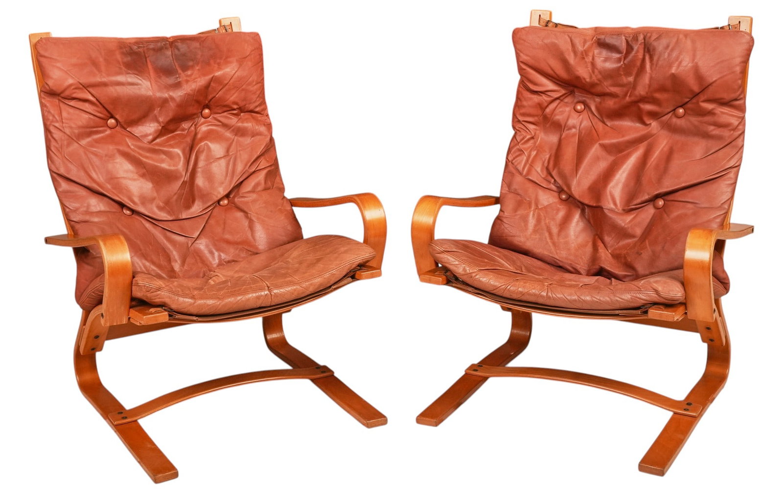 Pair of Norwegian Mid-Century Leather Lounge Chairs: Pair of Norwegian mid-century lounge chairs, bent laminated wood frames with suspended button-tufted cognac leather cushions, curved armrests and cantilevered bases, circa 1970s height 40.5 in. x
