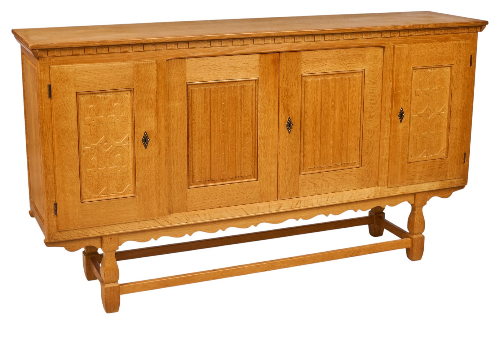 Henning Kjaernulf, Mid-Century Credenza: Henning Kjaernulf (Denmark) oak mid-century credeneza with four decoratively carved cabinet doors opening series of small trays and drawers on left side, and wide shelved cabinet on middle and left,