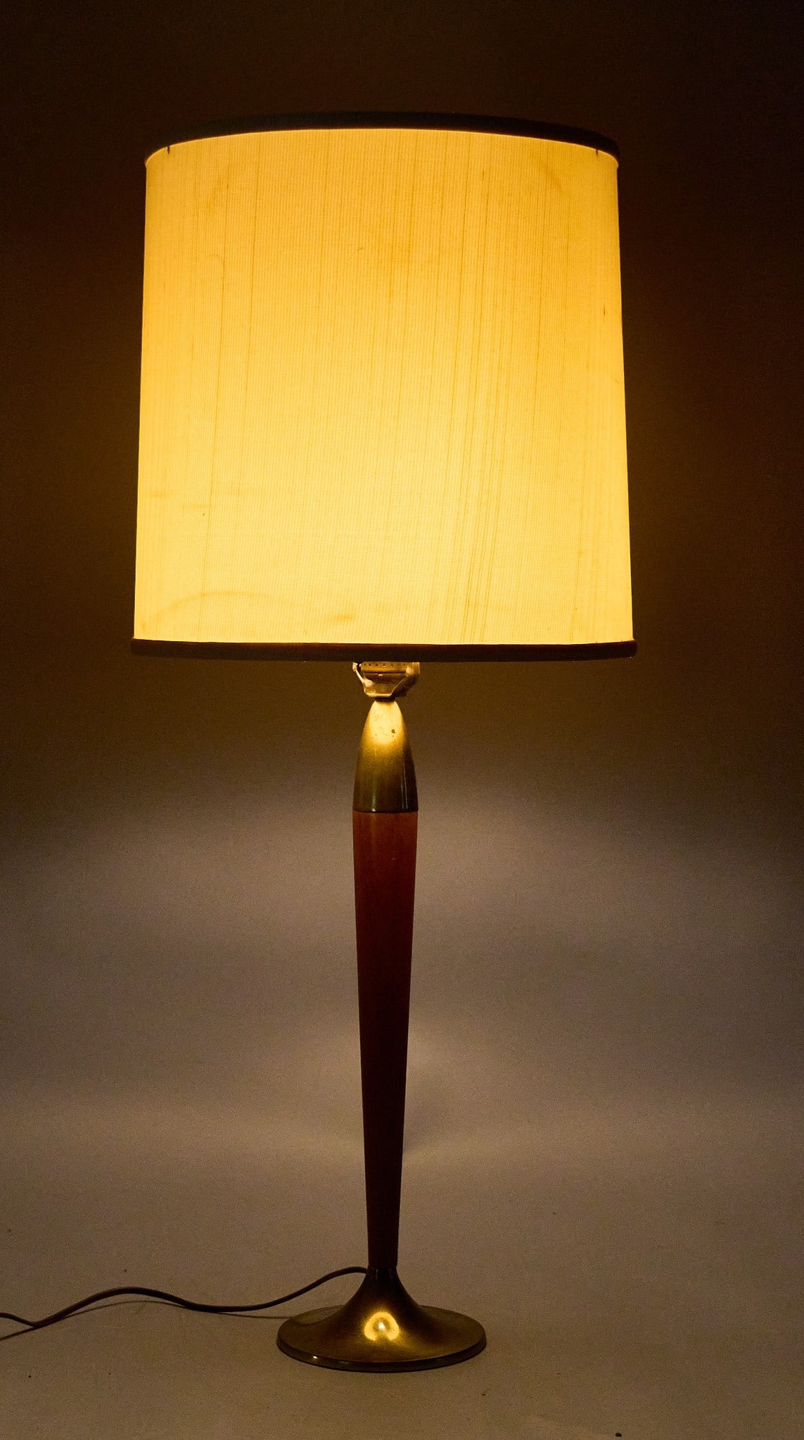 Mid-Century Torpedo Lamp: Mid-century wood and brass table lamp featuring torpedo-shaped stem, and shade, in working condition height 33.5 in. x diameter 13 in. Provenance: Property from a home in San Antonio, Texas Condition: