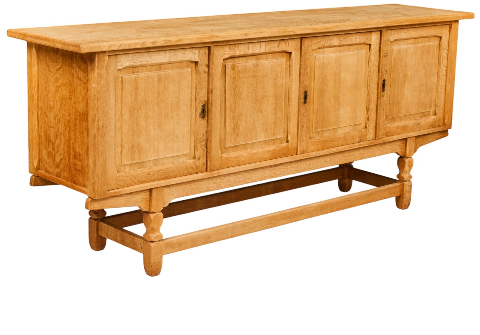 Danish Mid-Century Oak Sideboard: Danish mid-century oak sideboard, rectangular top above four paneled cabinet doors with brass key escutcheons, raised on shaped supports joined by perimeter stretchers height 35.5 in. x width 84.5 in.