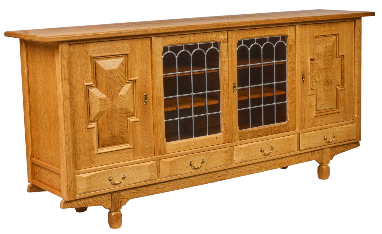 Henning Kjaernulf, Mid-Century Credenza: Henning Kjaernulf (Denmark) oak mid-century credenza with four carved cabinet doors opening to interiors with felt-lined trays, and shelving, above four lower drawers with metal pulls, supported
