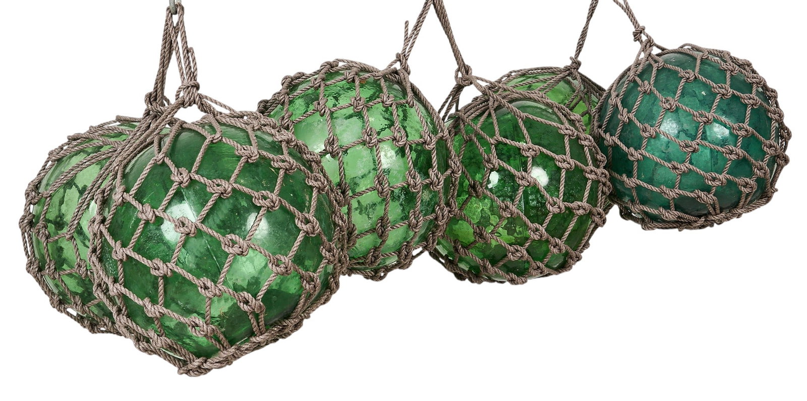 (6) Glass Nautical Floats: Six glass nautical floats encased in rope netting height 12 in. x width 12 in. x depth 12 in. / each Provenance: Property from a home in Rockport, Texas