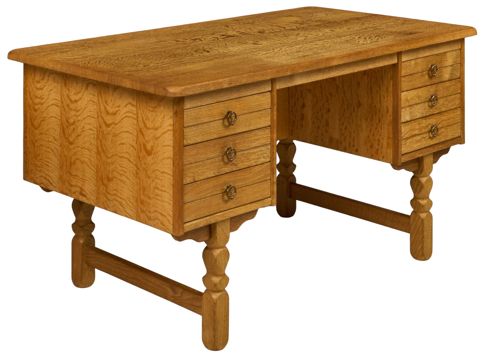 Danish Mid-Century Oak Desk: Danish mid-century oak desk, overhanging top above opposing banks of three drawers with brass ring pulls, figured quarter-sawn oak panels, raised on carved and turned legs joined by stretchers