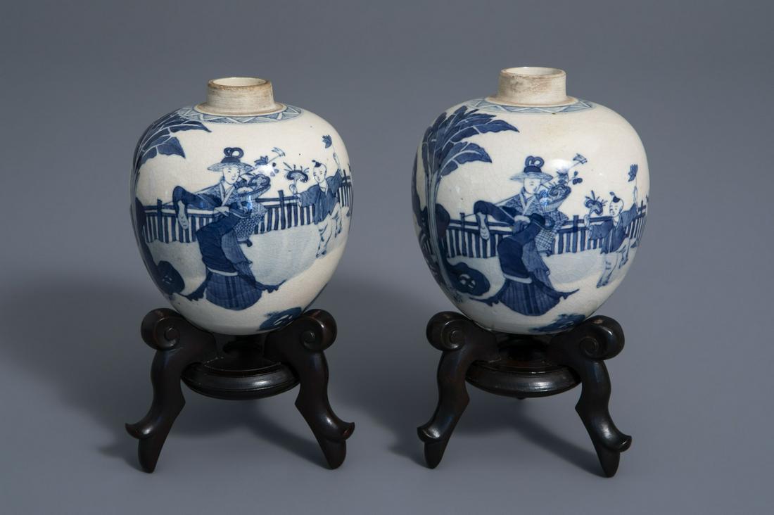 A pair of Chinese blue and white jars with figures in a: A pair of Chinese blue and white jars with figures in a garden, Kangxi mark, 19th/20th C. -- H 17,9 - 11,7 cm (with and without stand) -- -- -- Please request condition reports by e-mail on info@coron