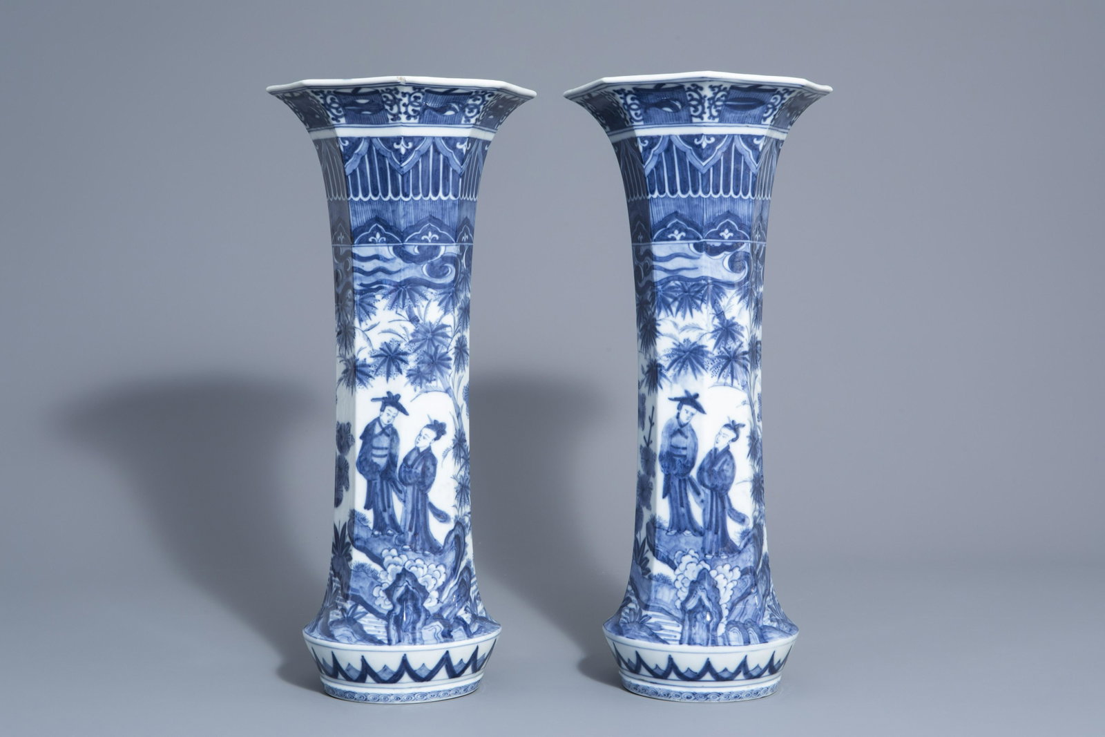 A pair of octagonal Japanese blue and white vases with: A pair of octagonal Japanese blue and white vases with figures in a landscape, Meiji/Showa, 20th C. H 53 cm