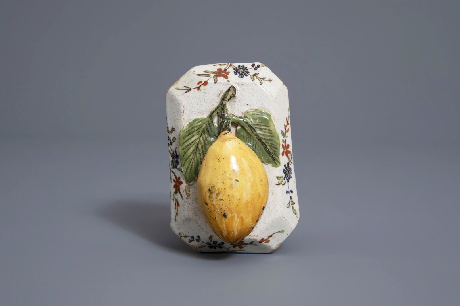 A polychrome Dutch Delft model of a lemon on a base,: A polychrome Dutch Delft model of a lemon on a base, about 1800 12 x 8,5 x 5,5 cm