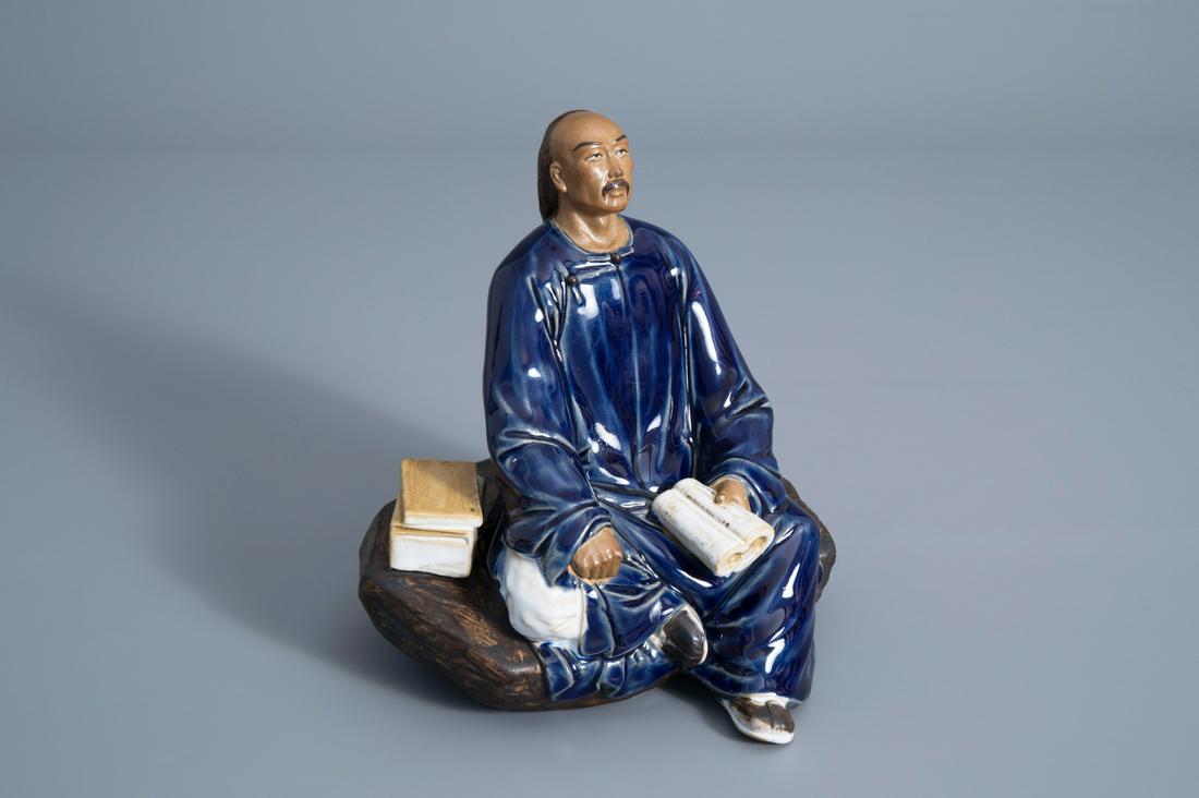 A Chinese Shiwan pottery figure of a man with a book, (1 of 8)