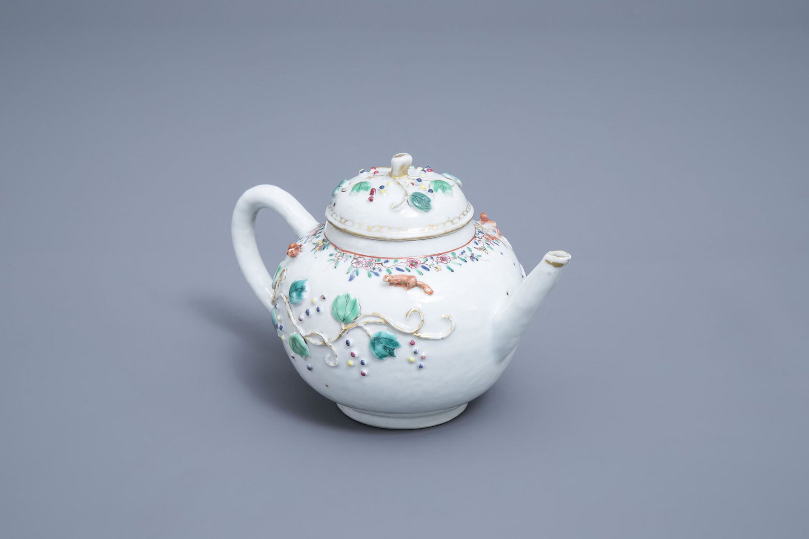 A Chinese famille rose teapot and cover with floral: Full title: A Chinese famille rose teapot and cover with floral relief design and squirrels, Yongzheng Description: H 13,3 - L 20,5 cm Condition:Please contact us to let us know which lots are of inte