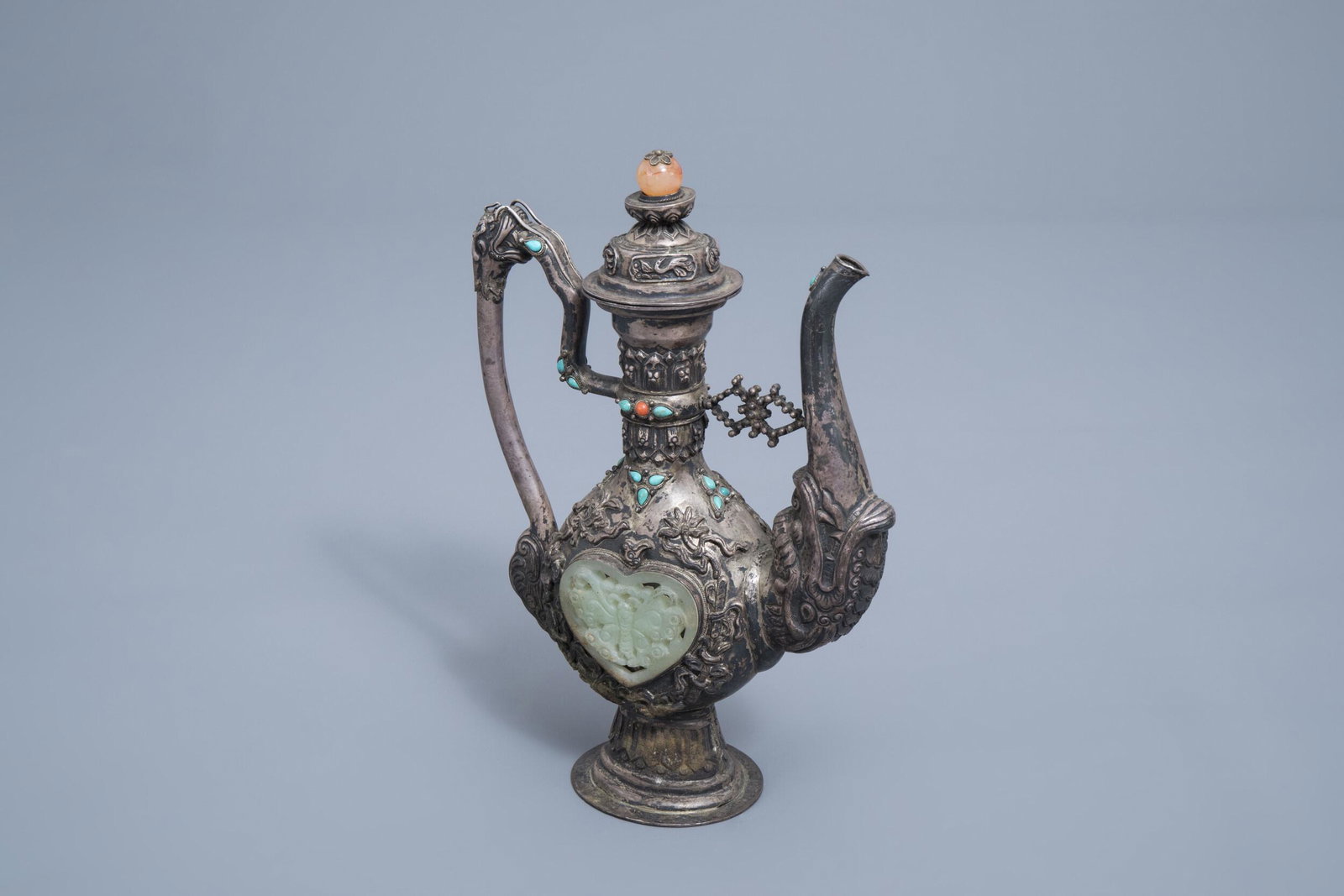 A coral, jade and turquoise inlaid silver ewer and: Full title: A coral, jade and turquoise inlaid silver ewer and cover, Tibet, 19th/20th C. Description: H 23,3 cm Total weight: 540 g Condition:Please contact us to let us know which lots are of intere