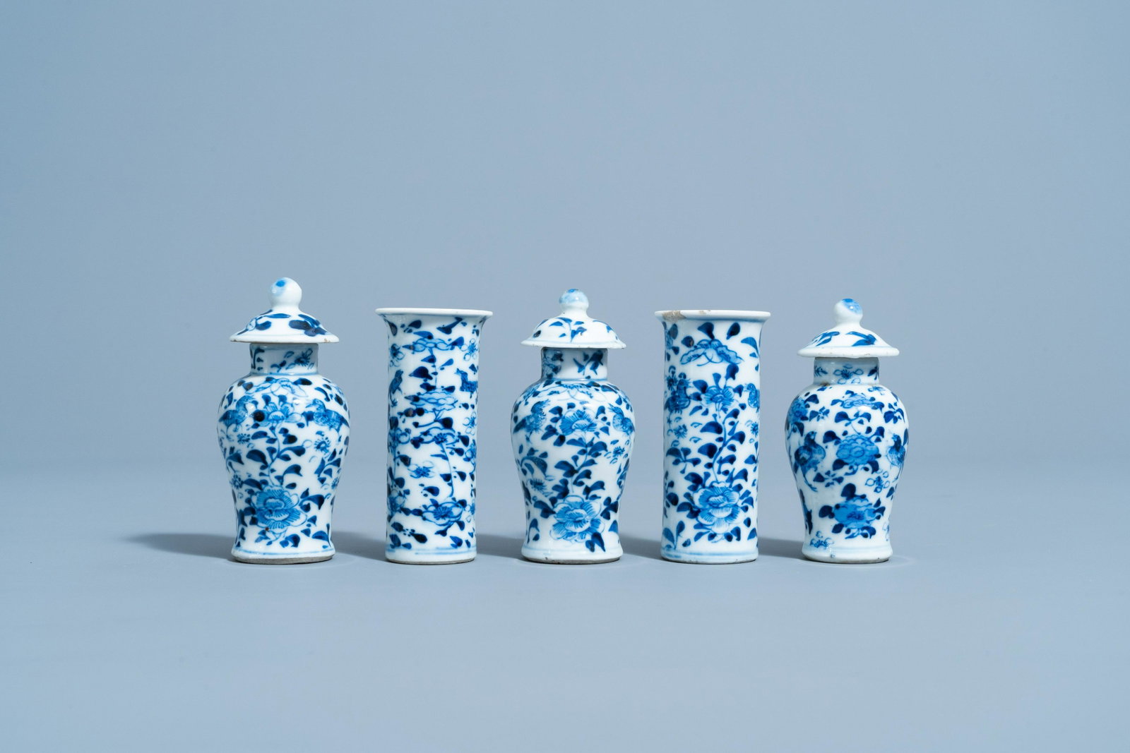 A Chinese blue and white five-piece garniture with: Full title: A Chinese blue and white five-piece garniture with floral design, 19th C. Description: H 10,1 - 9,3 cm