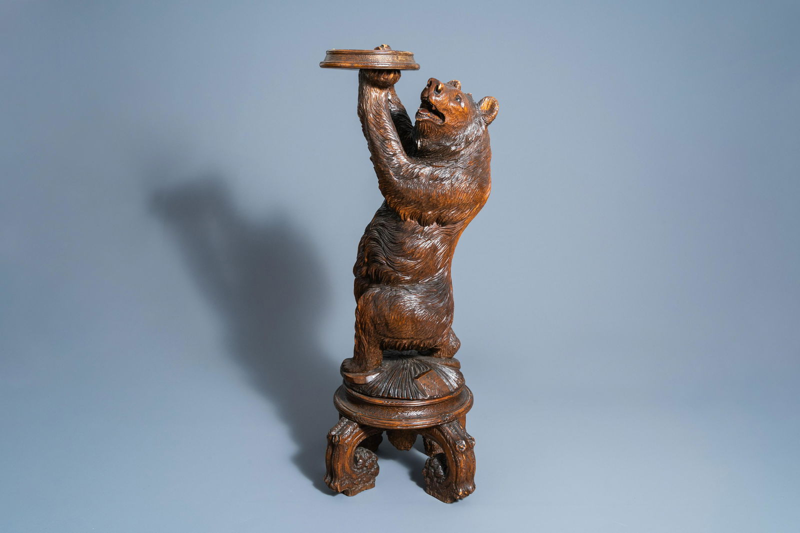 A carved wooden glass eyed bear shaped plant stand, (1 of 11)