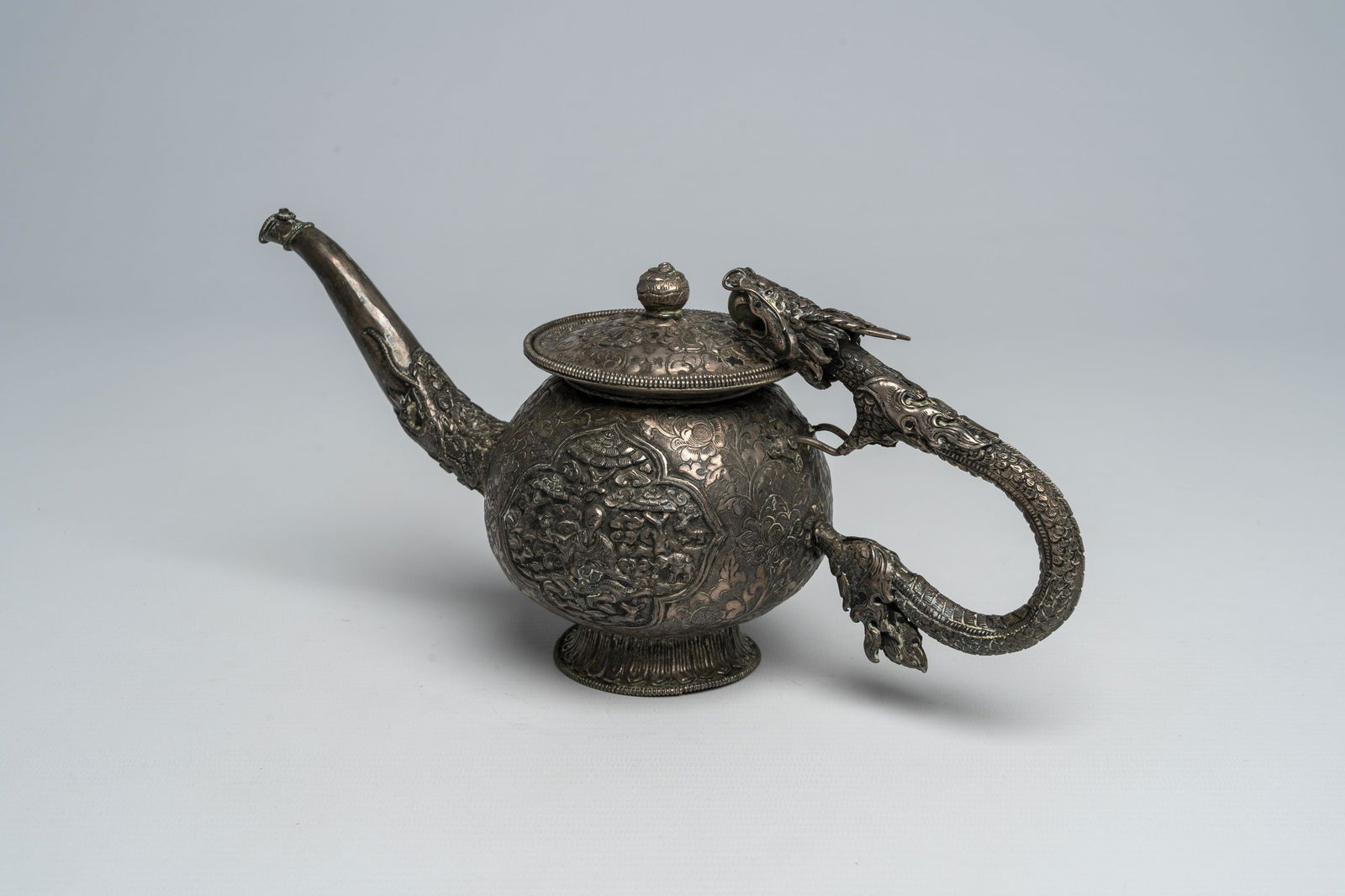 A Chinese silver teapot and cover with a dragon-shaped handle and a makara-shaped spout, 19th C. (1 of 10)