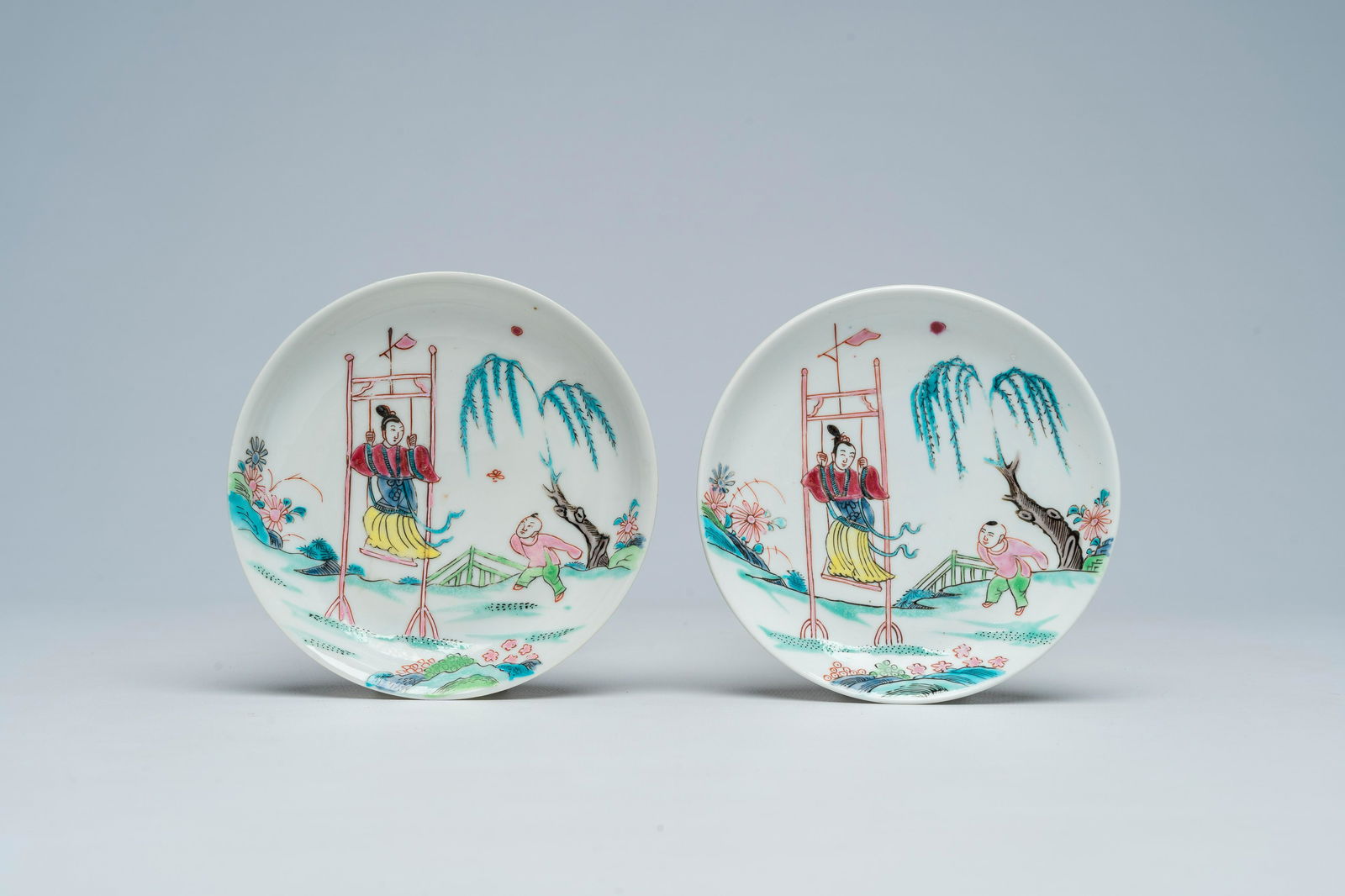 A pair of Chinese famille rose 'lady on a swing' saucers, Yongzheng (1 of 2)