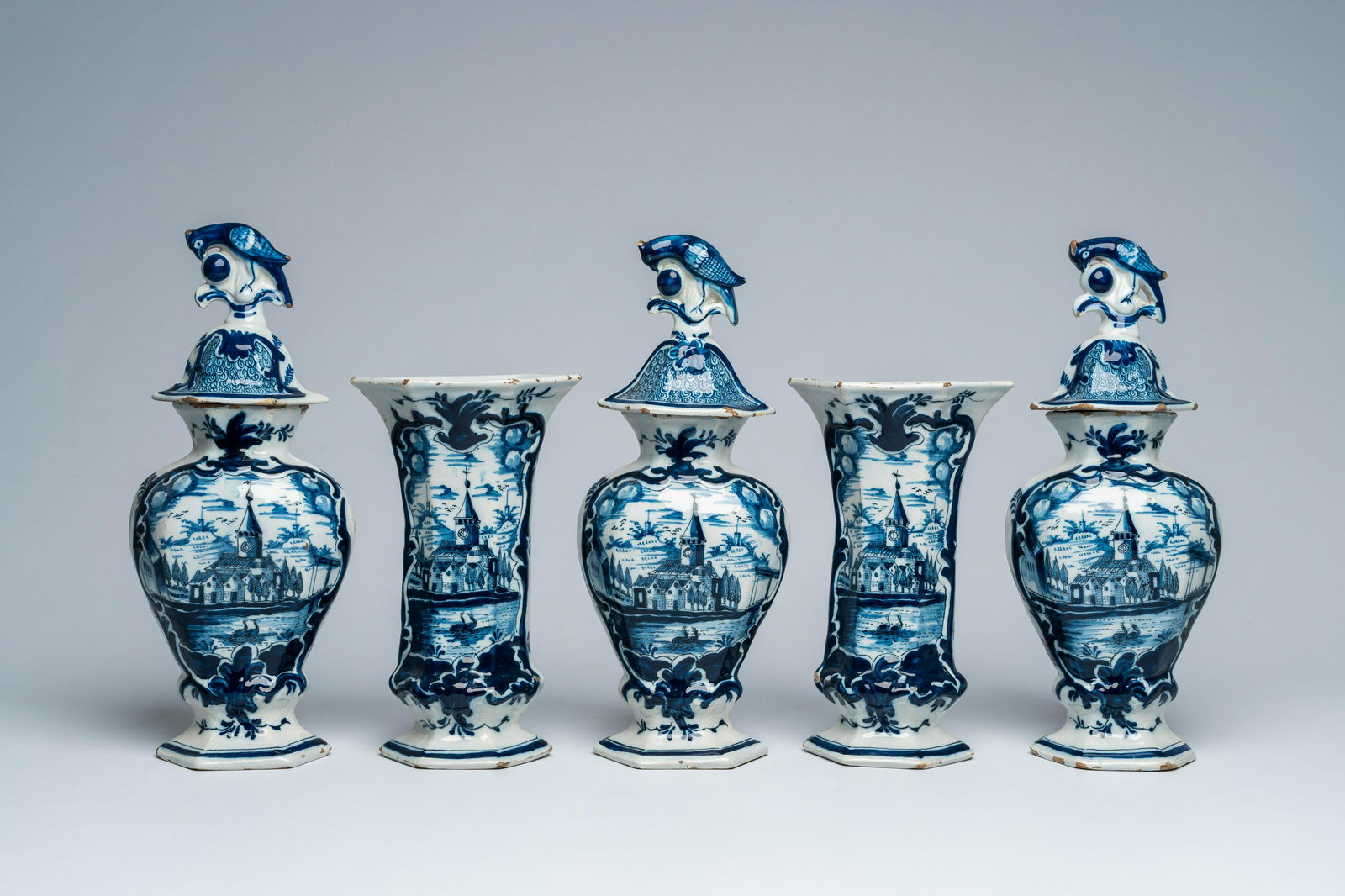 A Dutch Delft blue and white five-piece vase garniture with a landscape and floral design, 18th C.: Full title: A Dutch Delft blue and white five-piece vase garniture with a landscape and floral design, 18th C. Description: H 35,3 - 25,6 cm (the tallest and the smallest vase) The absence of a condit