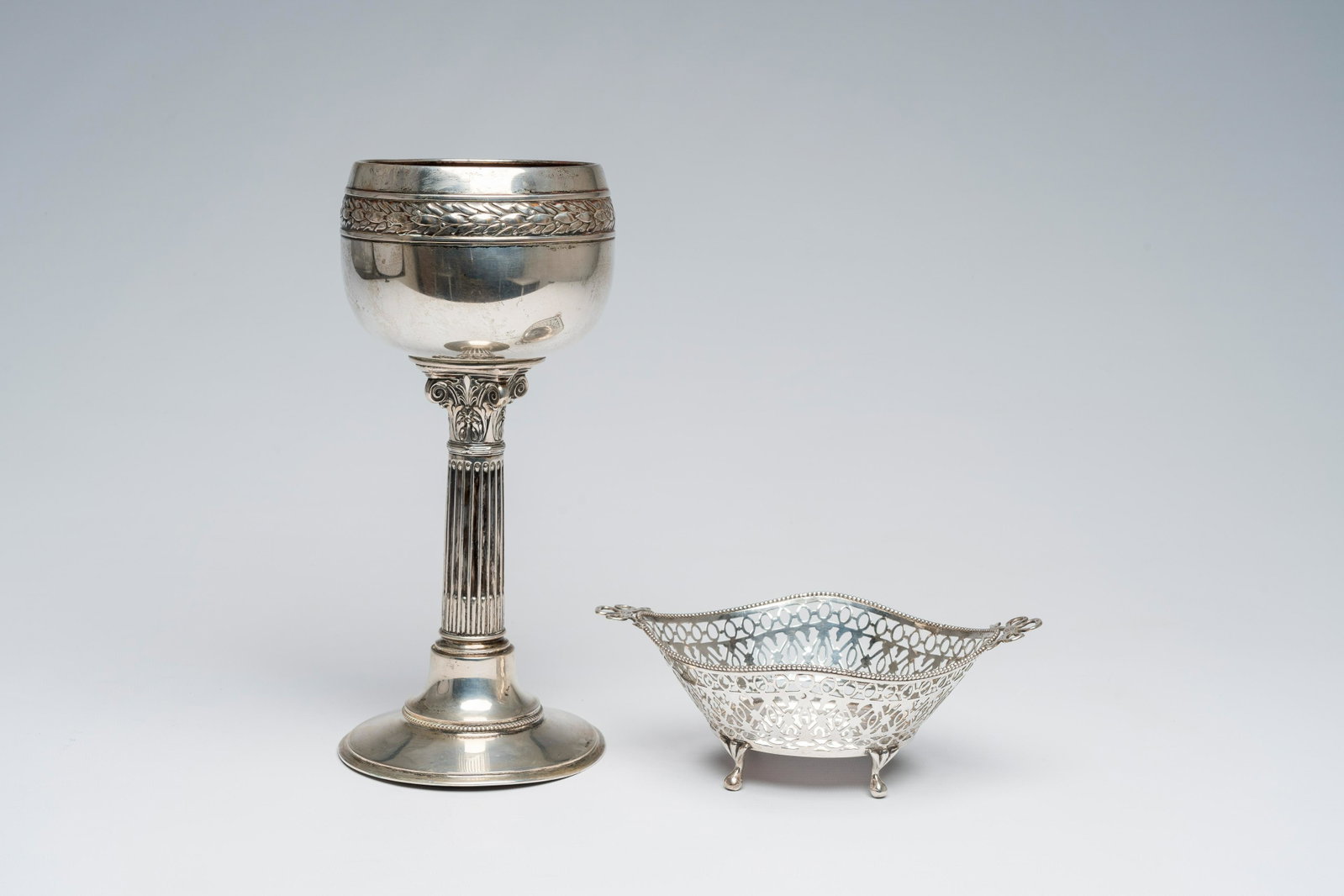 A German Neoclassical silver chalice and an open worked Dutch silver basket, 19th/20th C.: Full title: A German Neoclassical silver chalice and an open worked Dutch silver basket, 19th/20th C. Description: H 26,9 cm (the chalice) H 7,5 - L 19,7 cm (the basket) Total weight: 490 g The chalic
