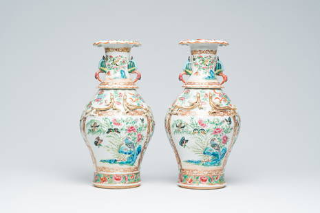 A pair of Chinese Canton famille rose vases with birds and butterflies among blossoming branches and: Title: A pair of Chinese Canton famille rose vases with birds and butterflies among blossoming branches and relief design of birds, 19th C. Description: H 42,5 cm