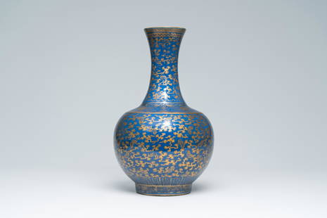 A Chinese blue ground gilt decorated 'bats amongst scrolling clouds' bottle vase, Guangxu mark and: Title: A Chinese blue ground gilt decorated 'bats amongst scrolling clouds' bottle vase, Guangxu mark and of the period Description: H 38 cm Ref.: - A very similar blue ground gilt decorated