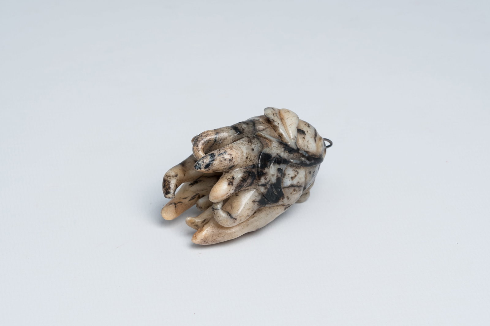 A Chinese carved black and white jade 'Buddha hand', 19th/20th C.: Full title: A Chinese carved black and white jade 'Buddha hand', 19th/20th C. Description: L 6,5 cm Condition reports and high resolution pictures are available on our website at www.coronariauctions.
